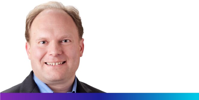 Hombre sonriendo sobre un fondo blanco.
