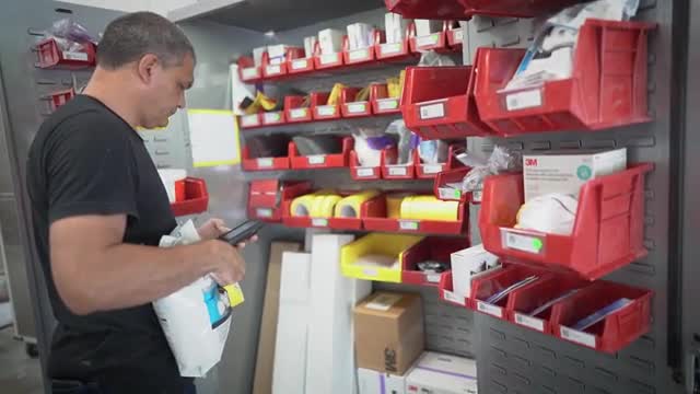 Hombre utilizando un RepairStack delante de contenedores de almacenamiento.
