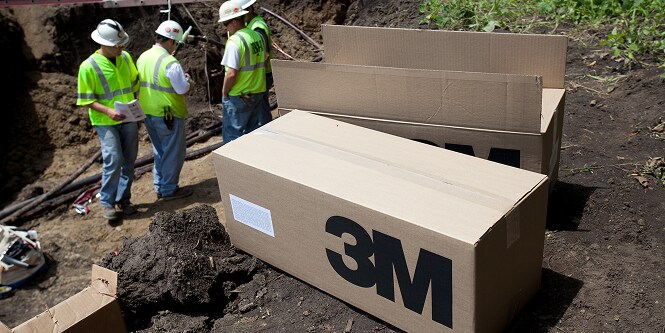 Cajas de productos 3M en el suelo cerca de trabajadores
