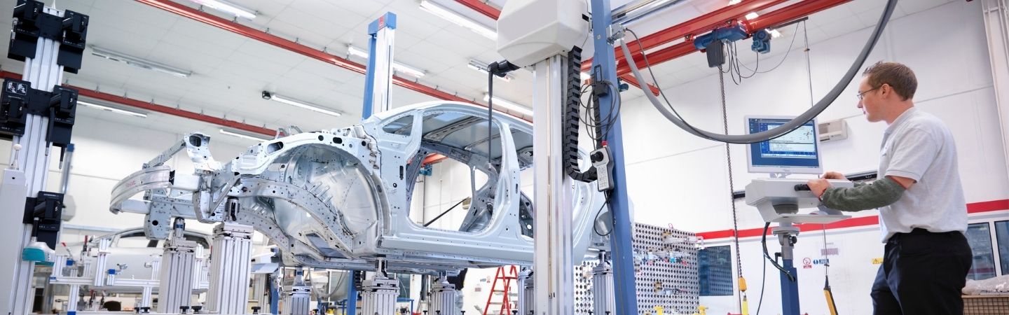 Trabajador de planta instalando componentes en una línea de montaje
