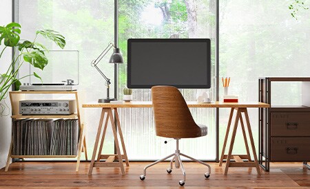 Zona de escritorio frente a una pared de ventanas con láminas de efecto espejo 3M
