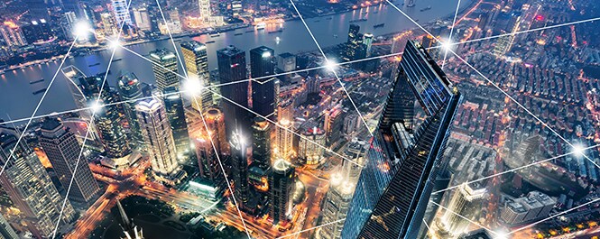 Paisaje urbano con una superposición gráfica de nodos de luz conectados por líneas rectas que crean un patrón geométrico.
