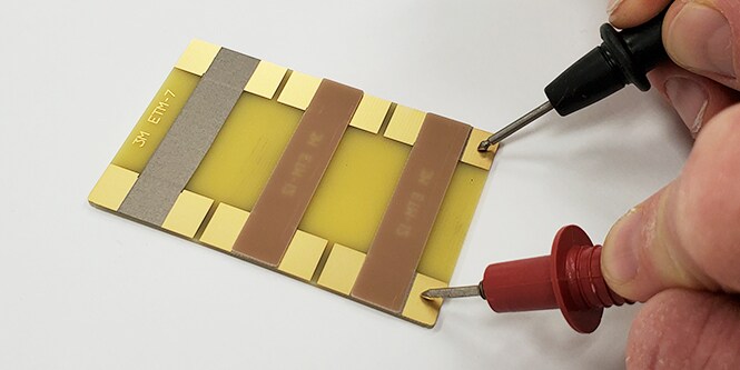 Persona probando la resistencia eléctrica en varios materiales. 
