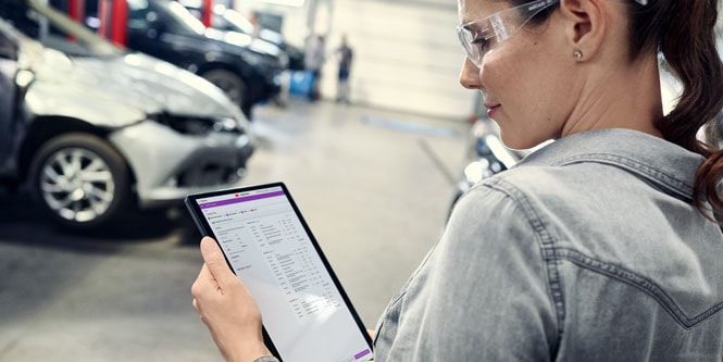 Mujer en un taller mirando la pantalla de una tableta.
