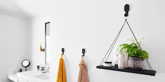 Pared de baño con ganchos 3M CLAW™ para plantas y toallas.
