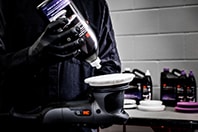 Imagen que muestra a una persona aplicando un líquido de desbatado a una boina Imagen que muestra a una persona aplicando un líquido de desbatado a una boina