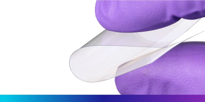 Gran primer plano de dos dedos doblando una lámina conductora transparente.
