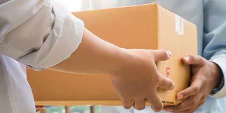 Una persona entrega una caja de cartón a otra.
