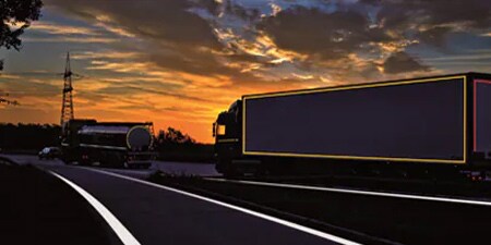 Camión en una carretera oscura con marcado para aumento de visibilidad
