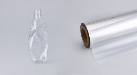 Botella de plástico junto a un rollo de lámina decorativa DI-NOC 
